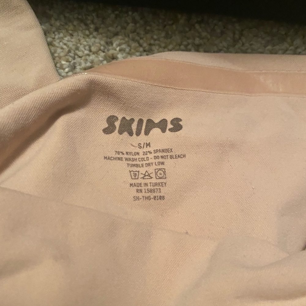 Two pairs of nude colored skim thongs, one high rise and one mid rise.
